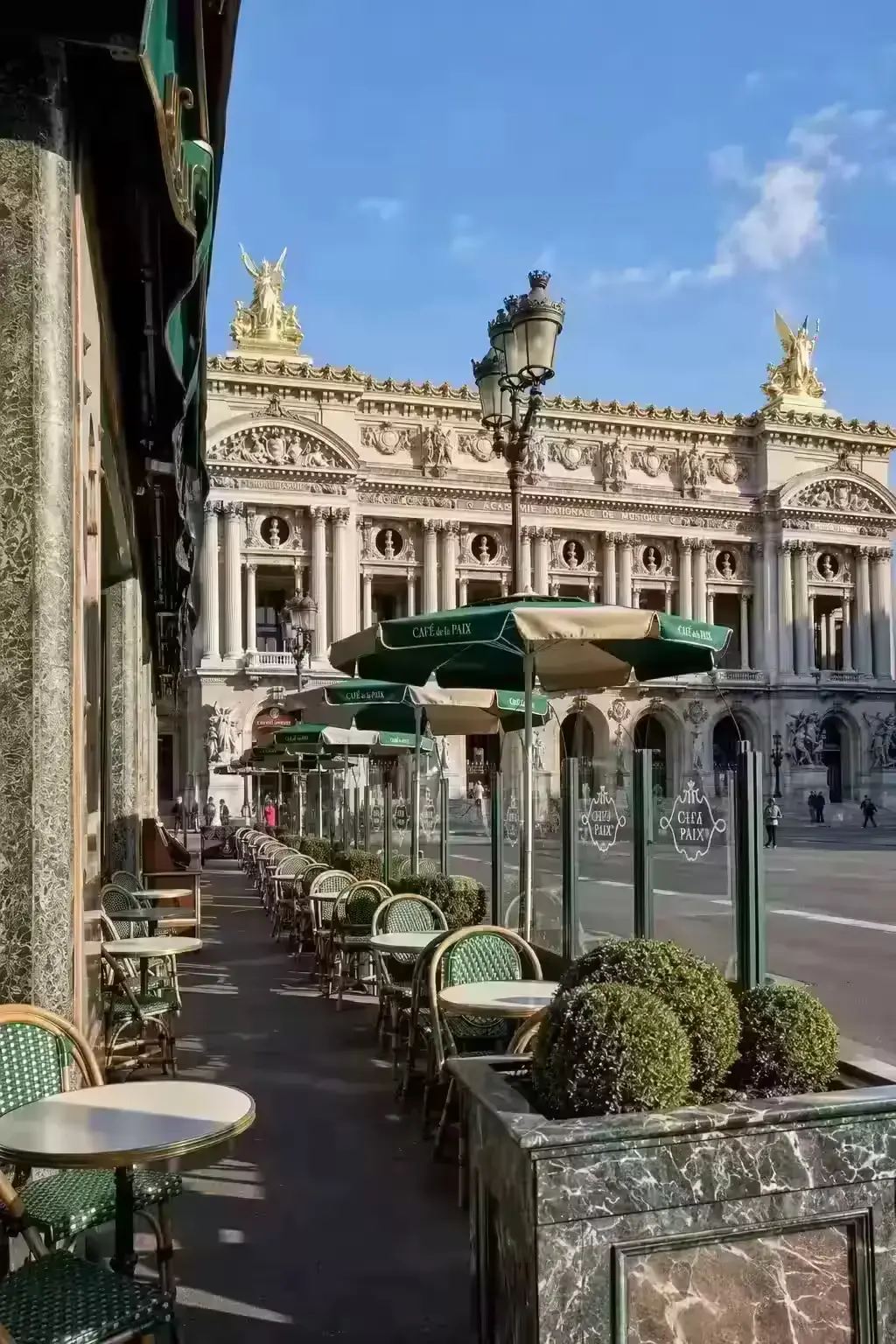A Paris caf&eacute; storefront with a red awning on a city street corner